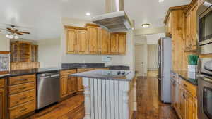 Kitchen featuring wood-finish cabinetry, dark countertops, and stainless steel appliances