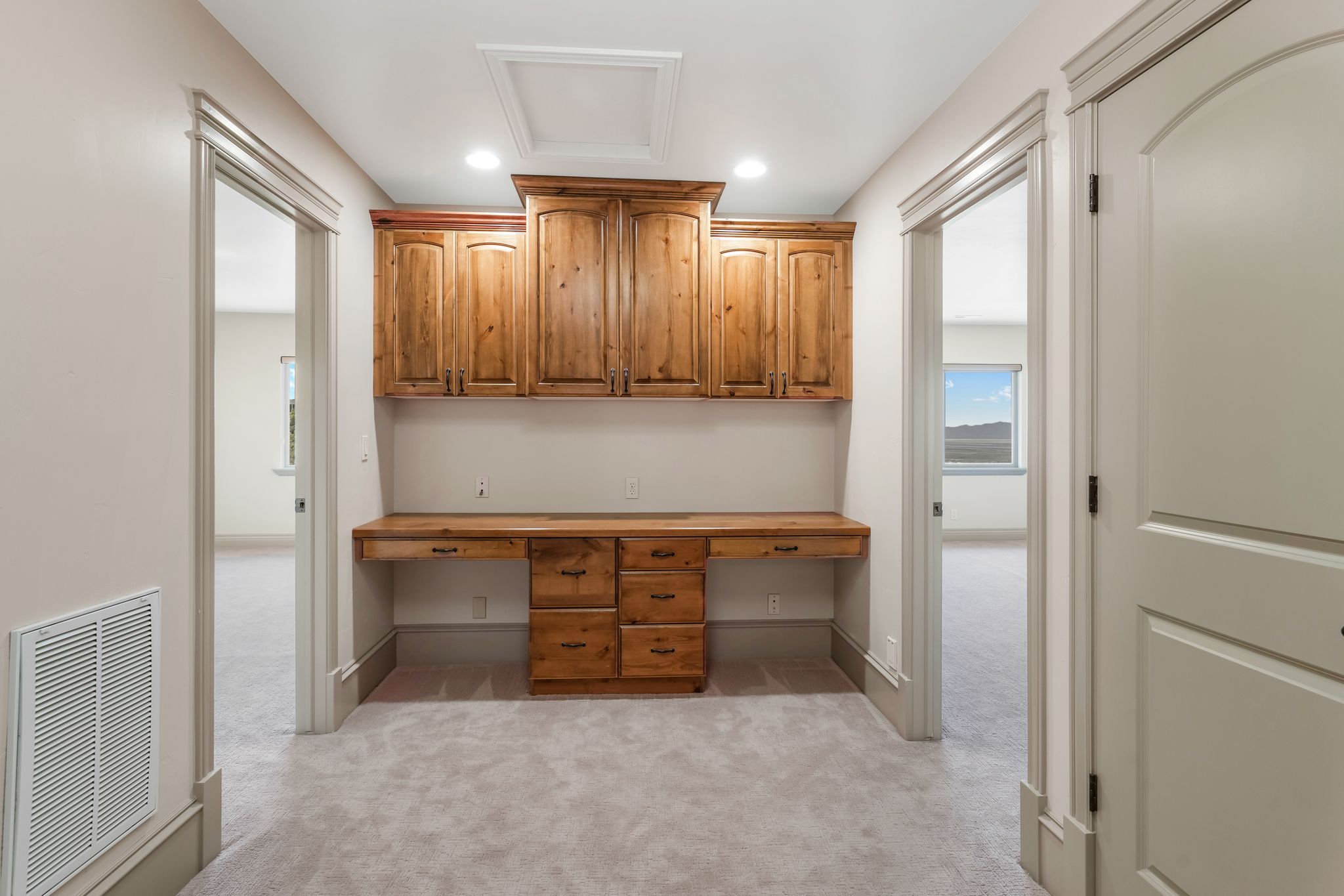 Built-in wood-finish desk with integrated cabinetry and drawers