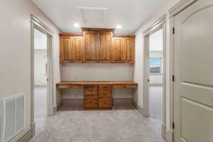 Built-in wood-finish desk with integrated cabinetry and drawers
