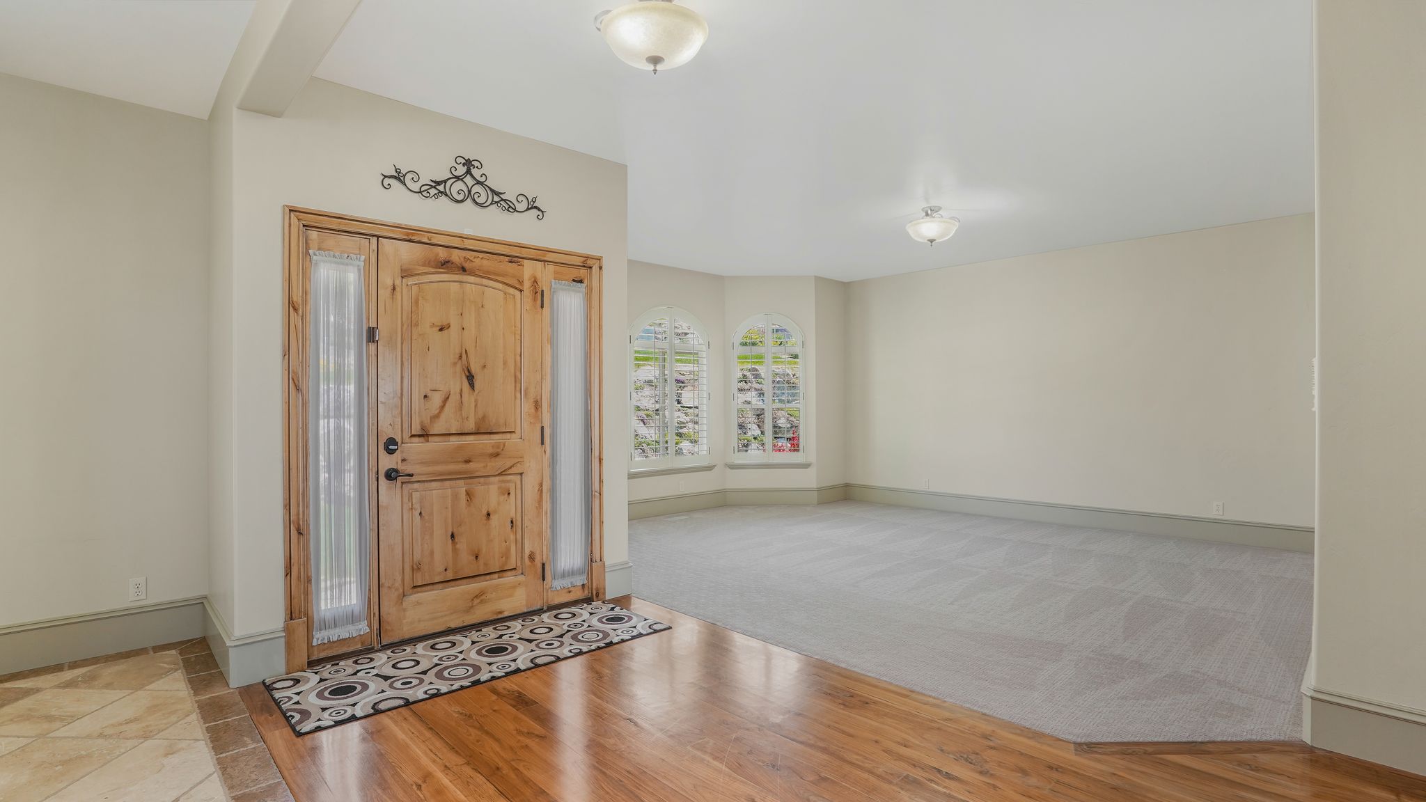 Grand entryway featuring a solid wood door with decorative sidelights
