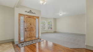Grand entryway featuring a solid wood door with decorative sidelights