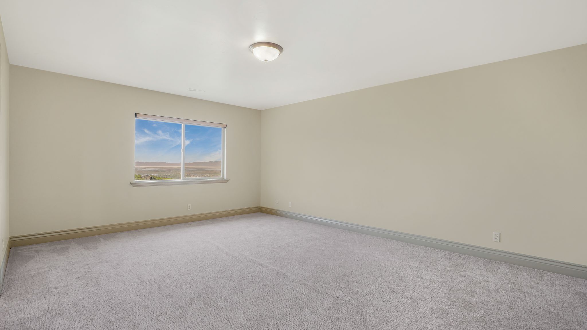Carpeted room with a single window and recessed baseboards