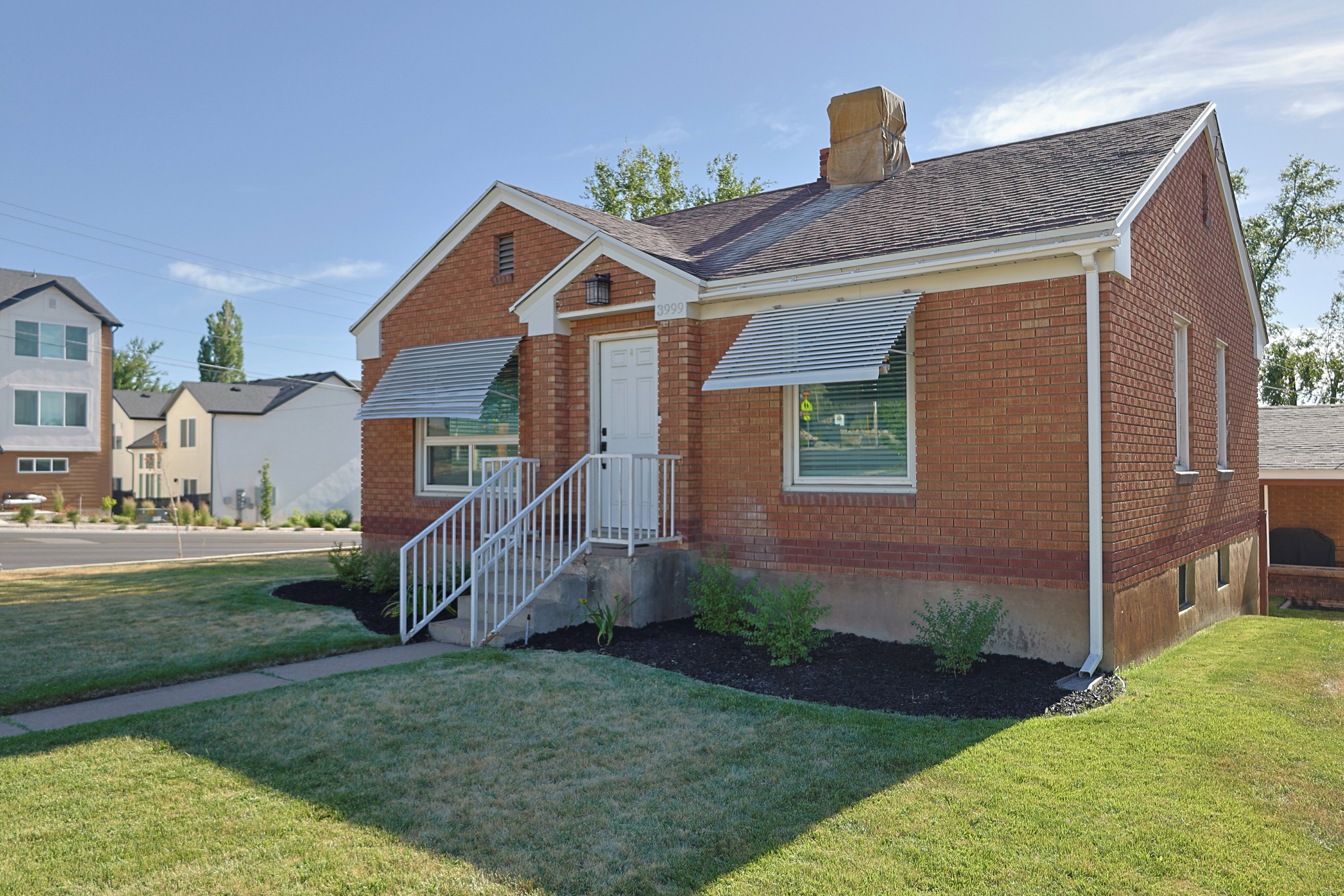 Brick exterior featuring a white entry door with an overhang