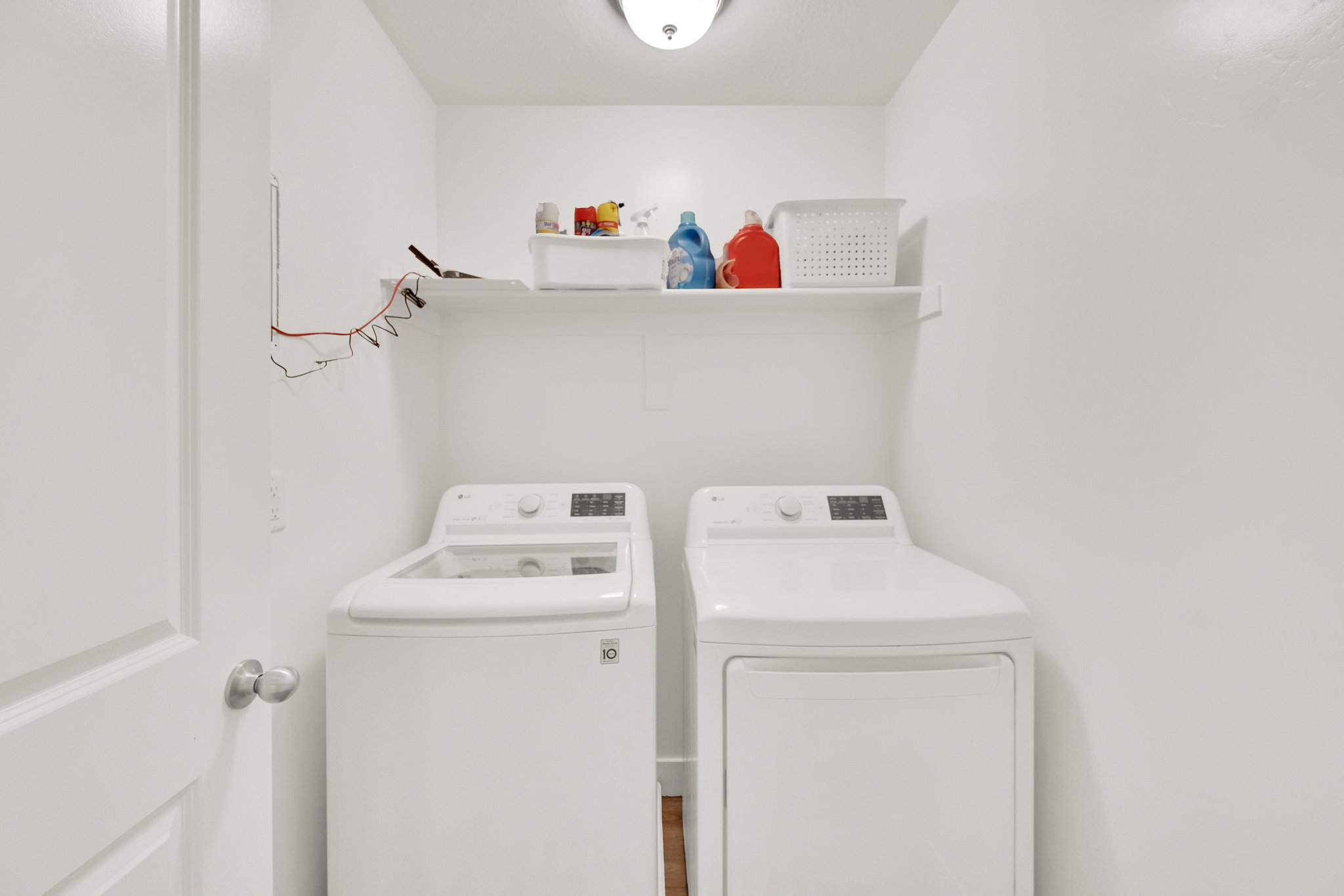 Dedicated laundry space featuring a white top-load washing machine and white dryer unit