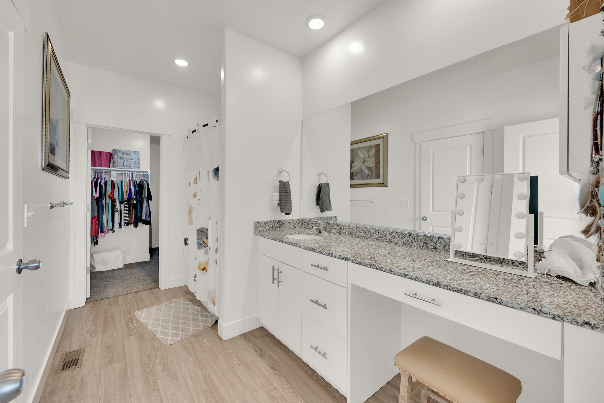 Bathroom vanity featuring a light-toned wood-finish floor and a spacious countertop with a built-in sink