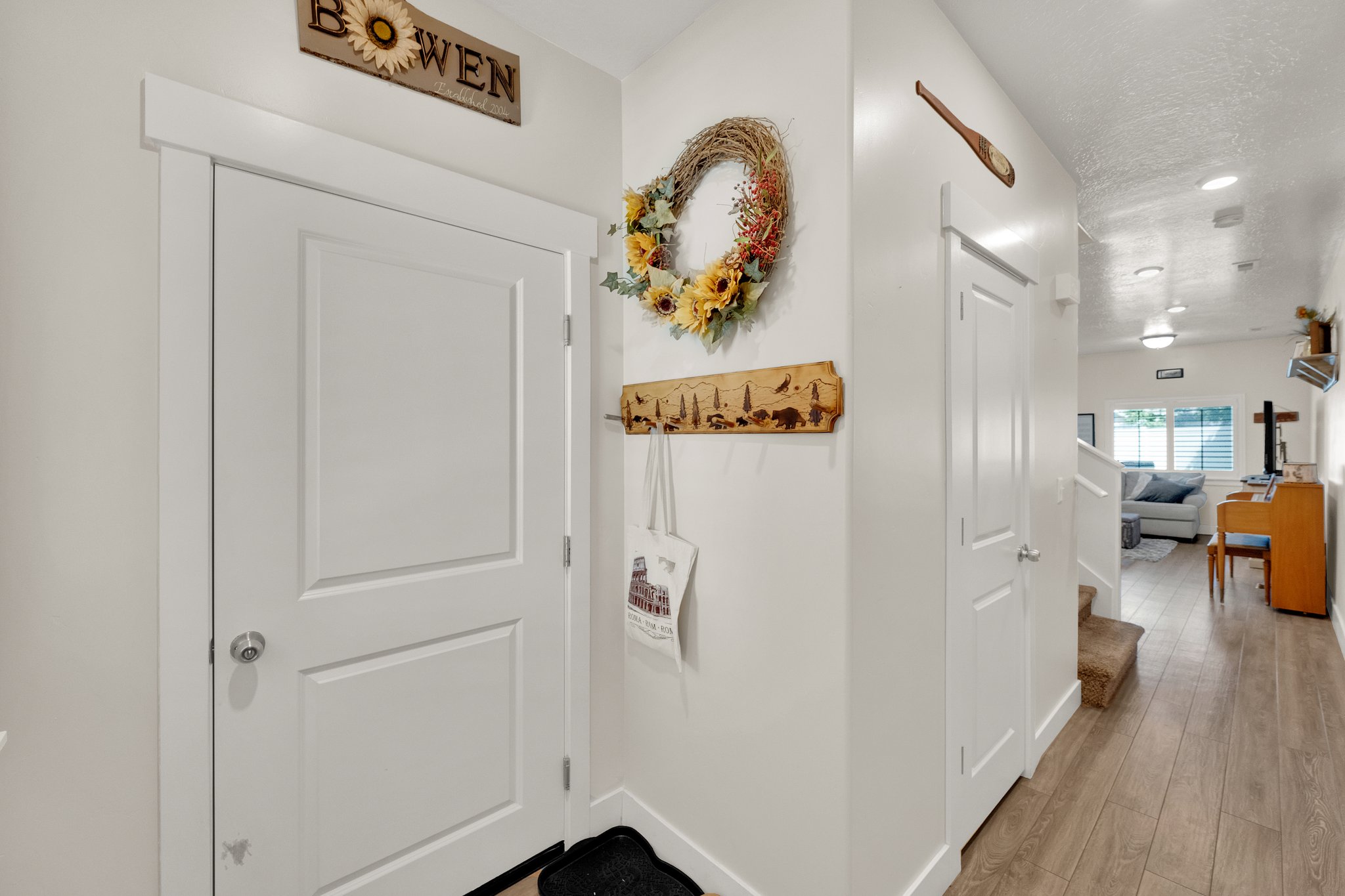 Entryway featuring a white paneled door with brushed nickel hardware, light wood-finish flooring, white baseboards, and recessed lighting