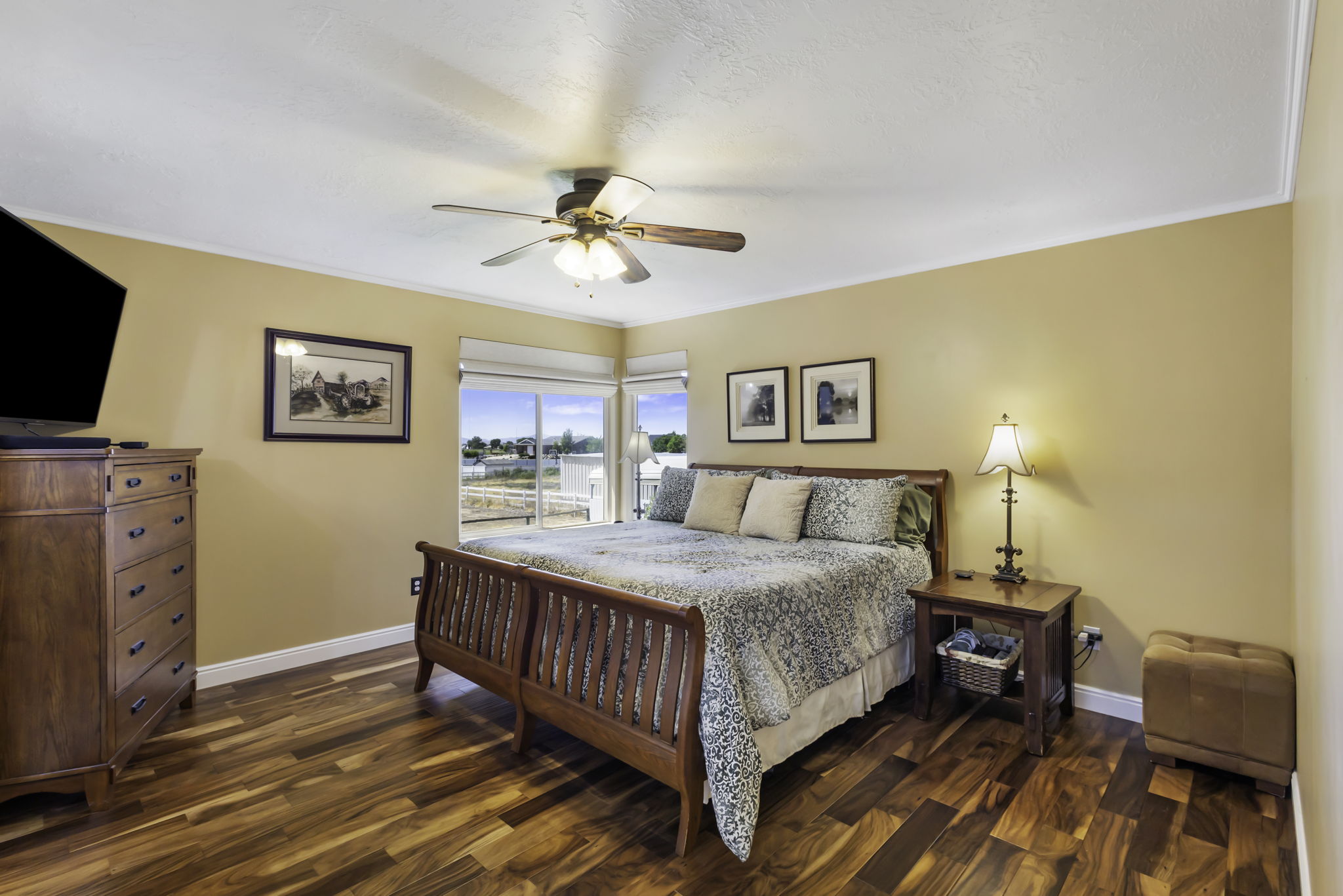 Bedroom featuring expansive windows, hardwood flooring, a ceiling fan, and crown molding