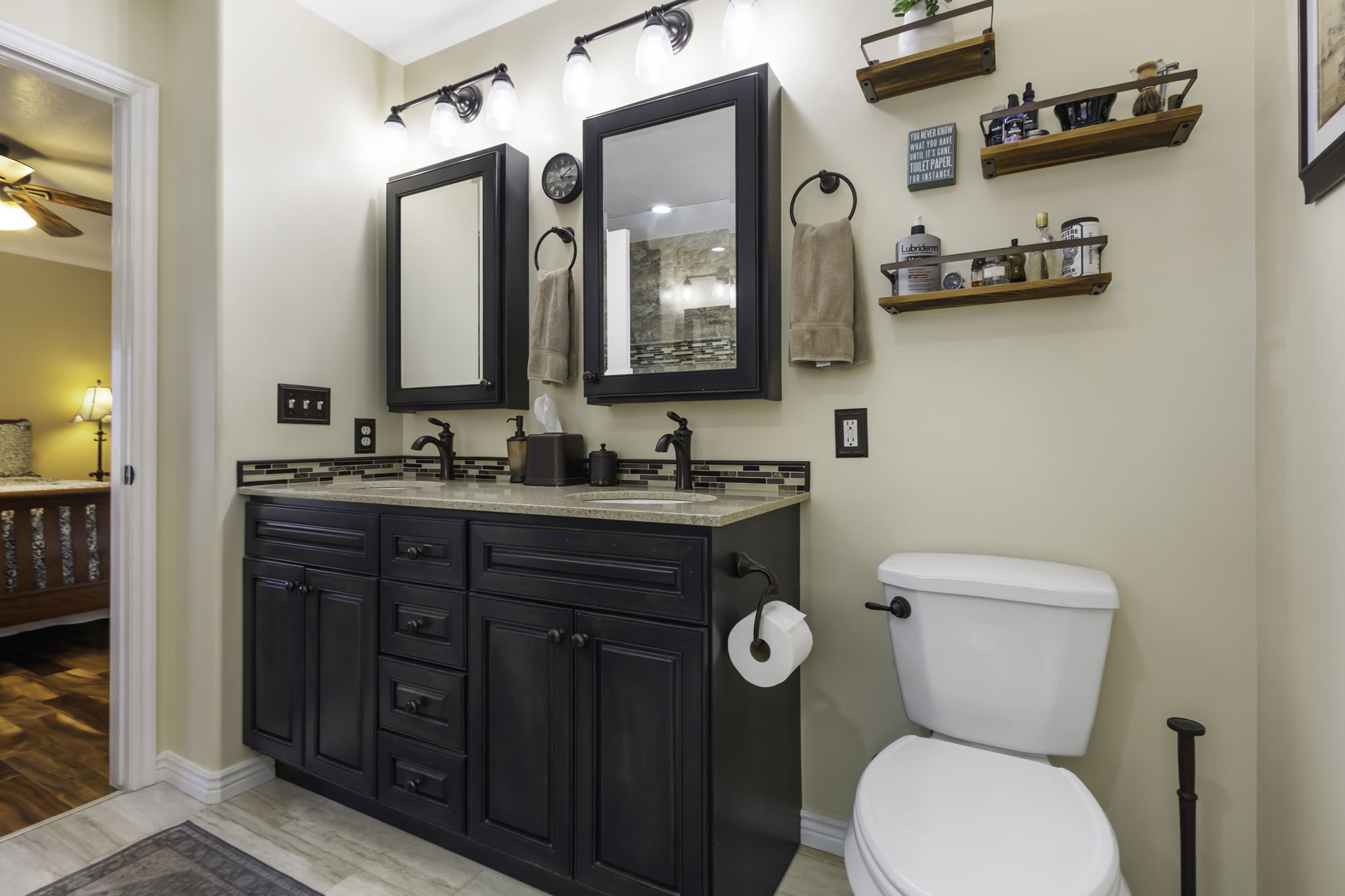 Double vanity with black cabinetry and light-toned countertops