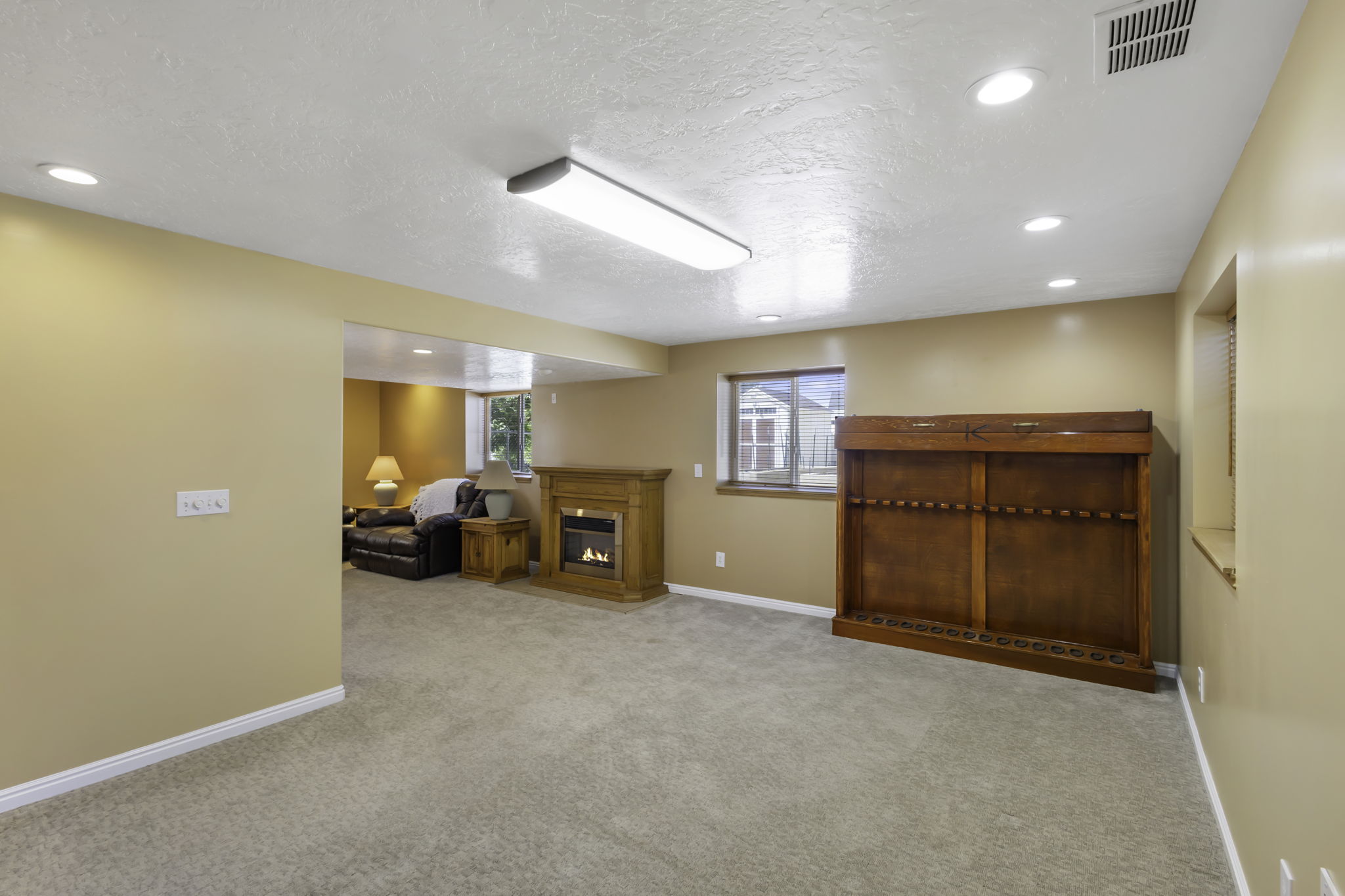 Carpeted lower level featuring an electric fireplace with blower for chilly nights
