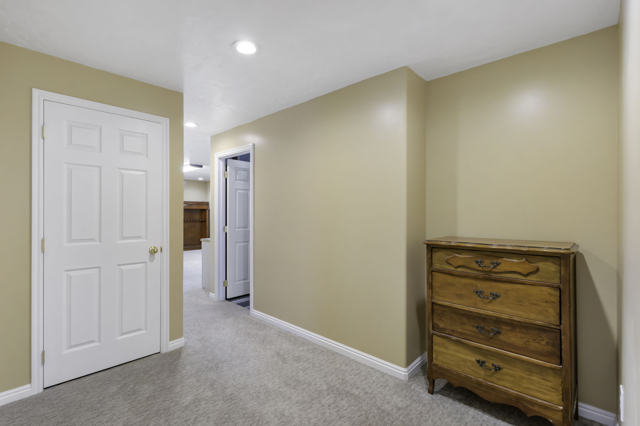 Hallway leading to a full bathroom and two good sized bedrooms