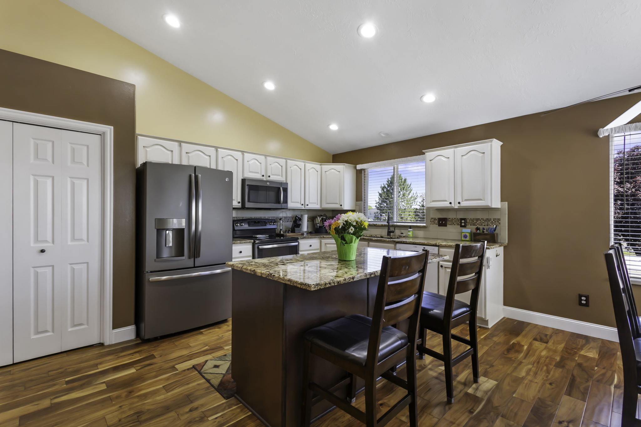 Kitchen featuring a central island with a granite countertop, mainly stainless steel appliances, and Hardwood flooring