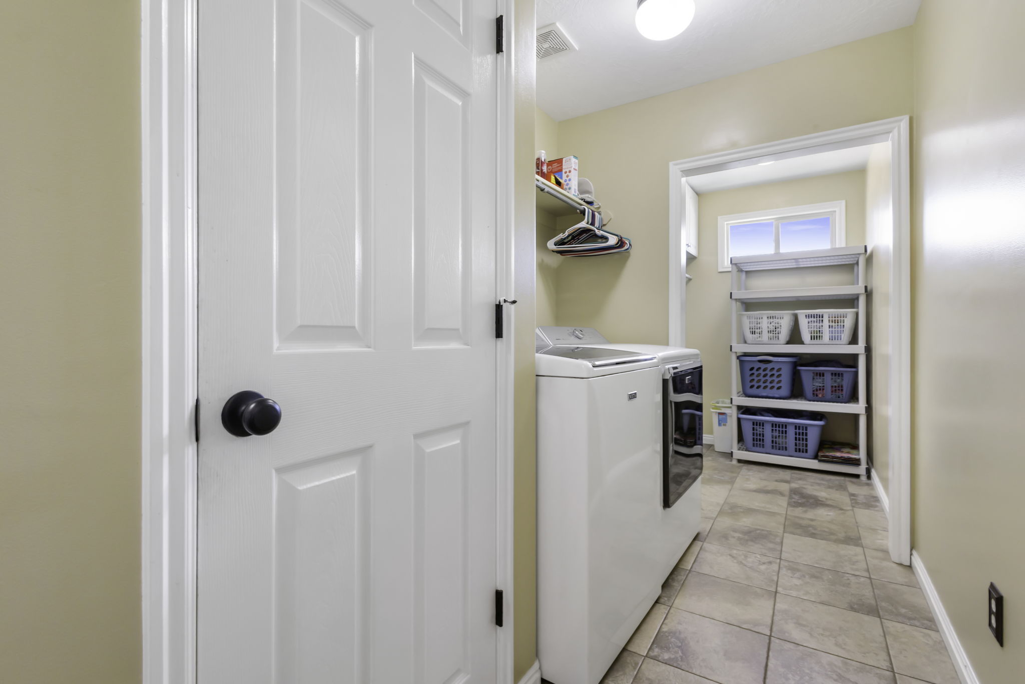 Main floor laundry room with ample storage  and tile flooring