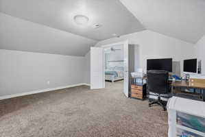 Carpeted room featuring a sloped ceiling and light gray walls