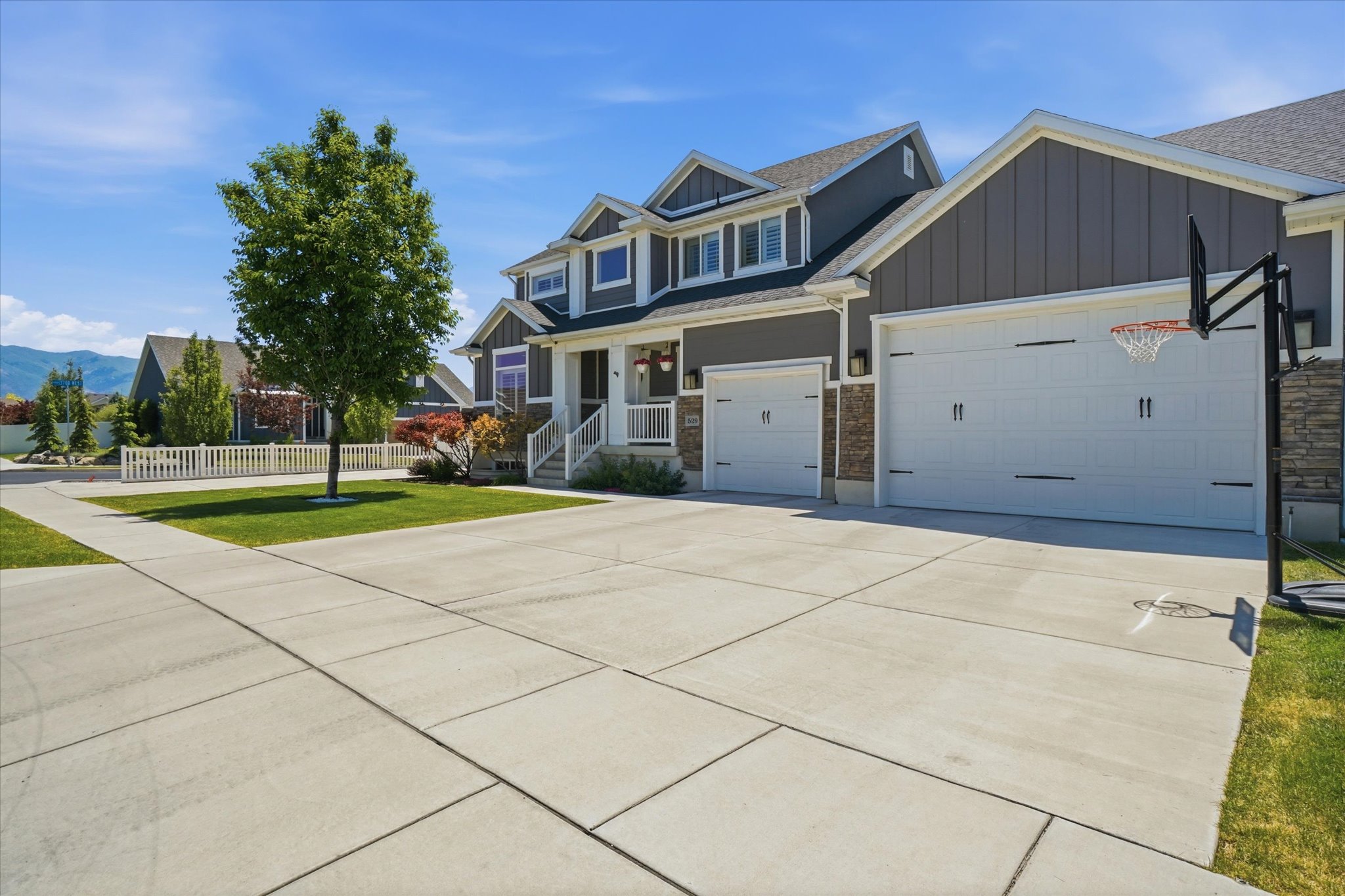 Contemporary two-story residence featuring dark gray siding, white trim, and stone accents