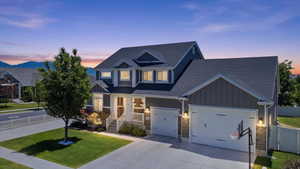 Contemporary two-story residence featuring a dark gray exterior, white trim, and stone accents