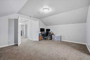 Carpeted room with sloped ceilings and light grey wall paint