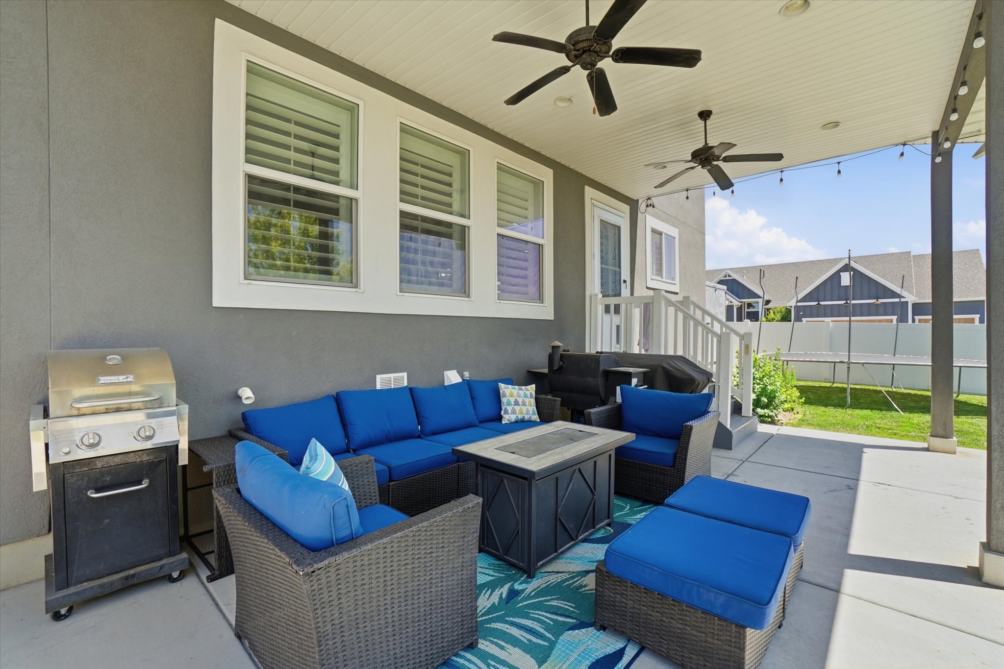 Covered patio featuring two ceiling fans, recessed lighting, and a white railing