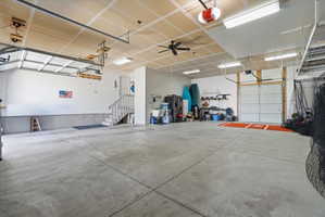 Spacious garage featuring concrete flooring, multiple garage doors, and ample overhead lighting
