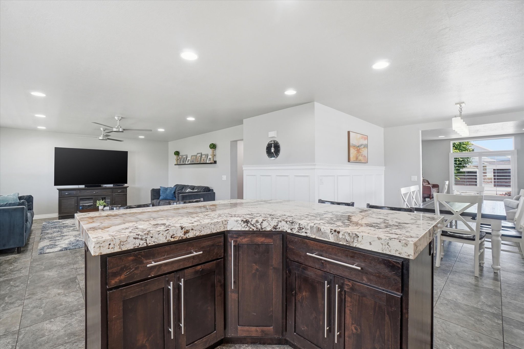 Kitchen island featuring dark wood cabinetry and a multi-toned stone countertop