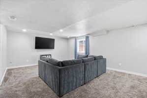 Spacious room featuring light gray walls, recessed lighting, and soft carpet flooring