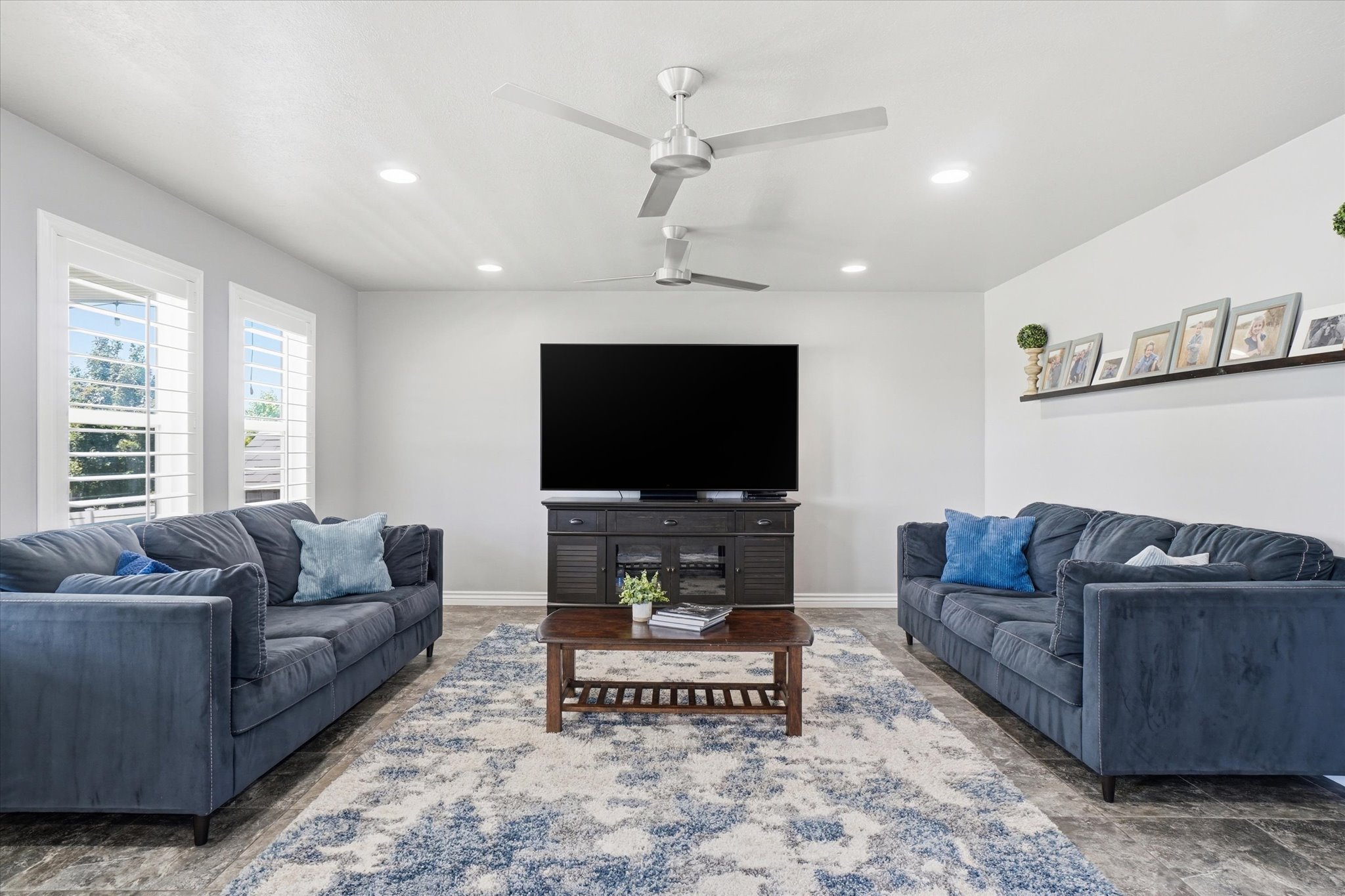 Spacious living area featuring recessed lighting, multiple ceiling fans, and wood-finish flooring