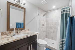 Bathroom featuring a dark wood vanity with a stone countertop, an undermount sink, and a brushed nickel faucet