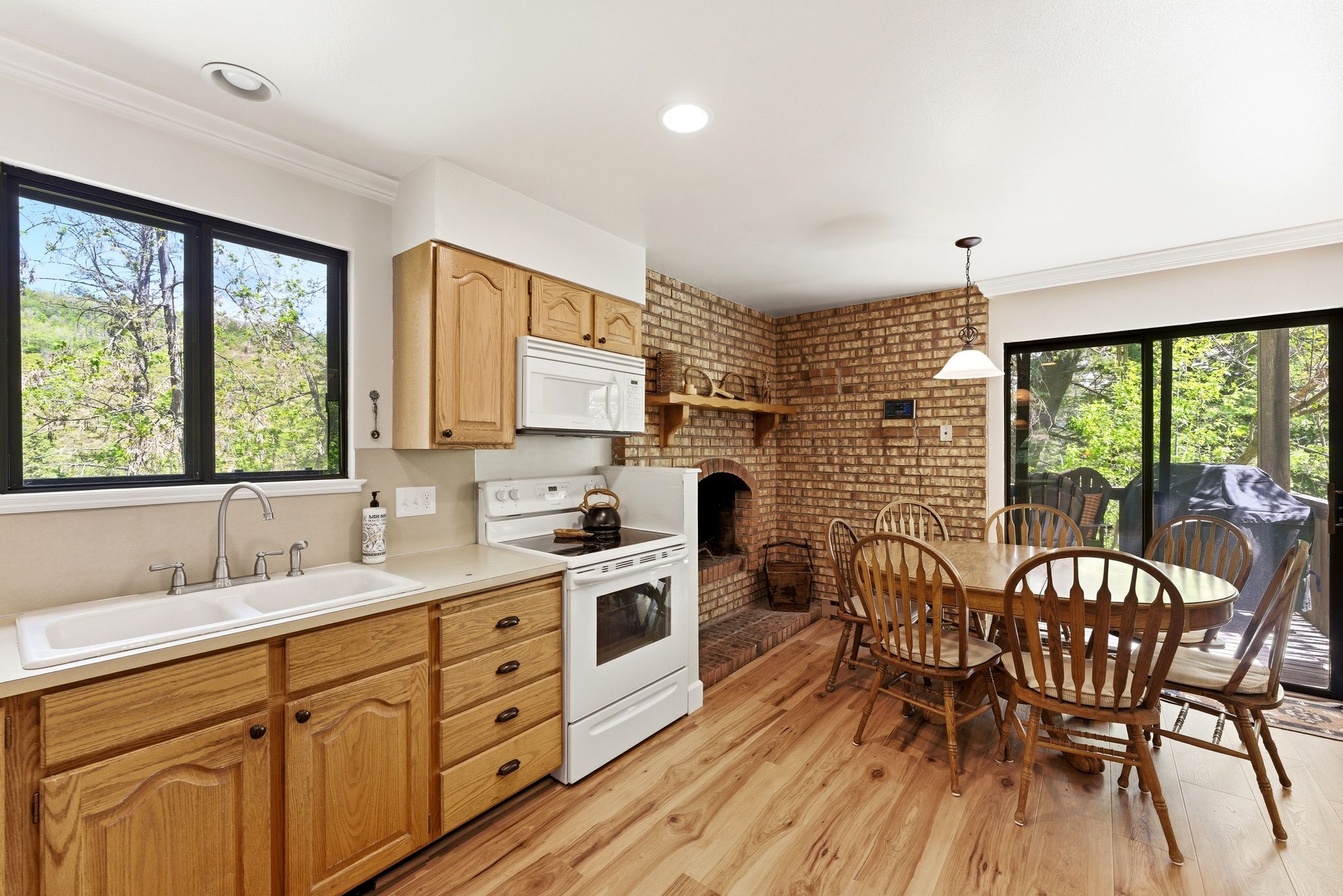 Kitchen with wood-finish flooring, light wood cabinetry, and a double basin sink
