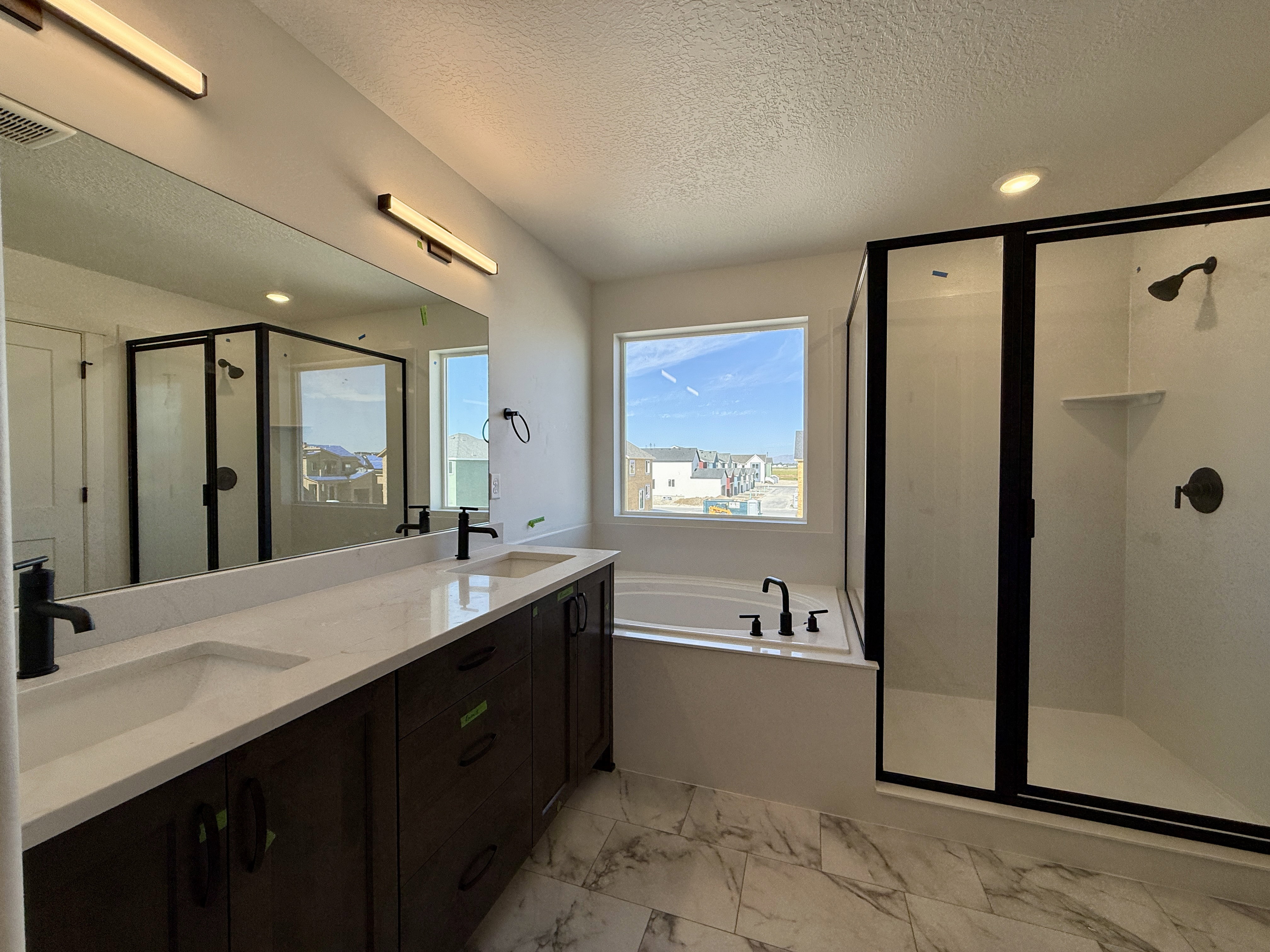 Bathroom featuring a dual vanity with dark wood-finish cabinetry and white countertops