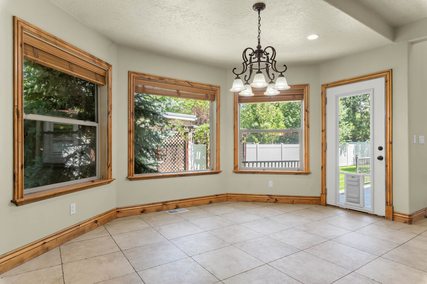 Dining area featuring light-toned tile flooring, substantial wood trim, and multiple large windows