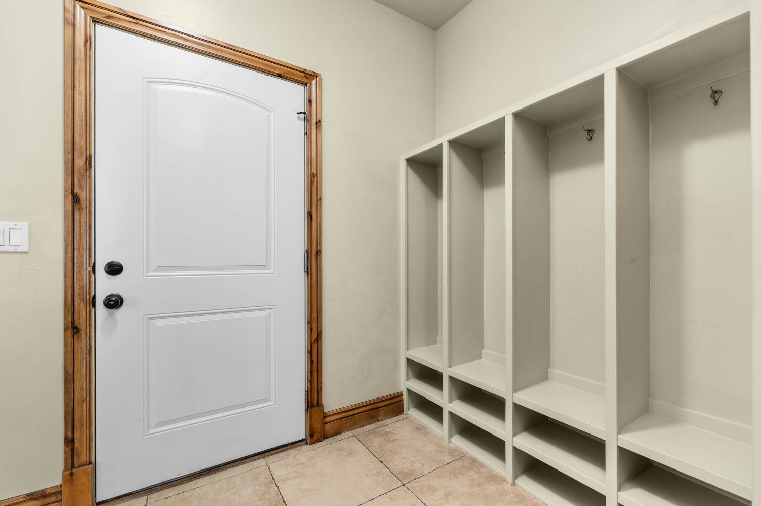 Built-in mudroom storage featuring individual cubbies with hooks and integrated shoe shelving