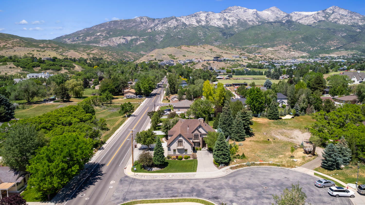Mountain backdrop with a residential street, a cul-de-sac, and mature trees