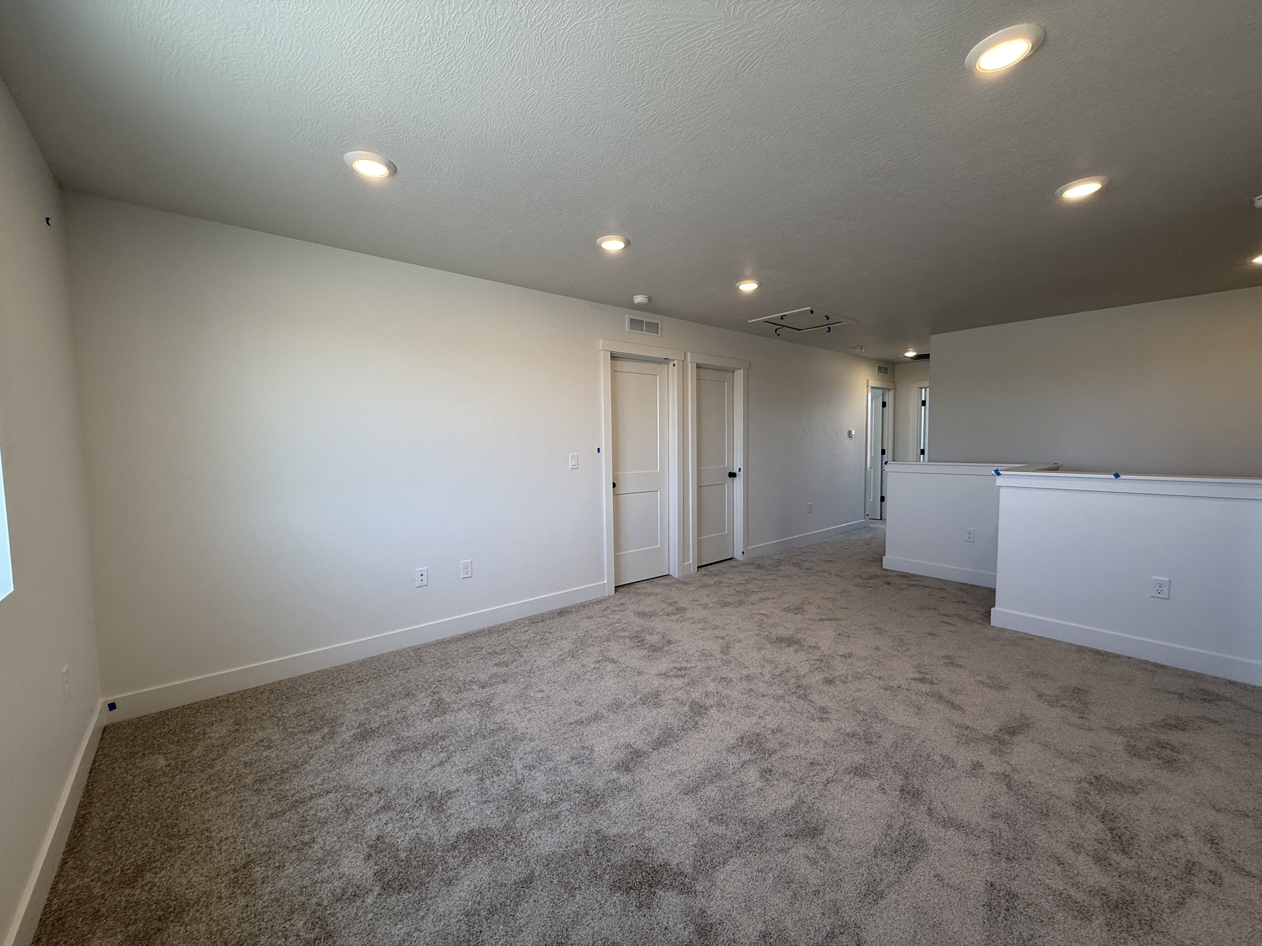 Spacious carpeted room featuring recessed lighting and white trim details