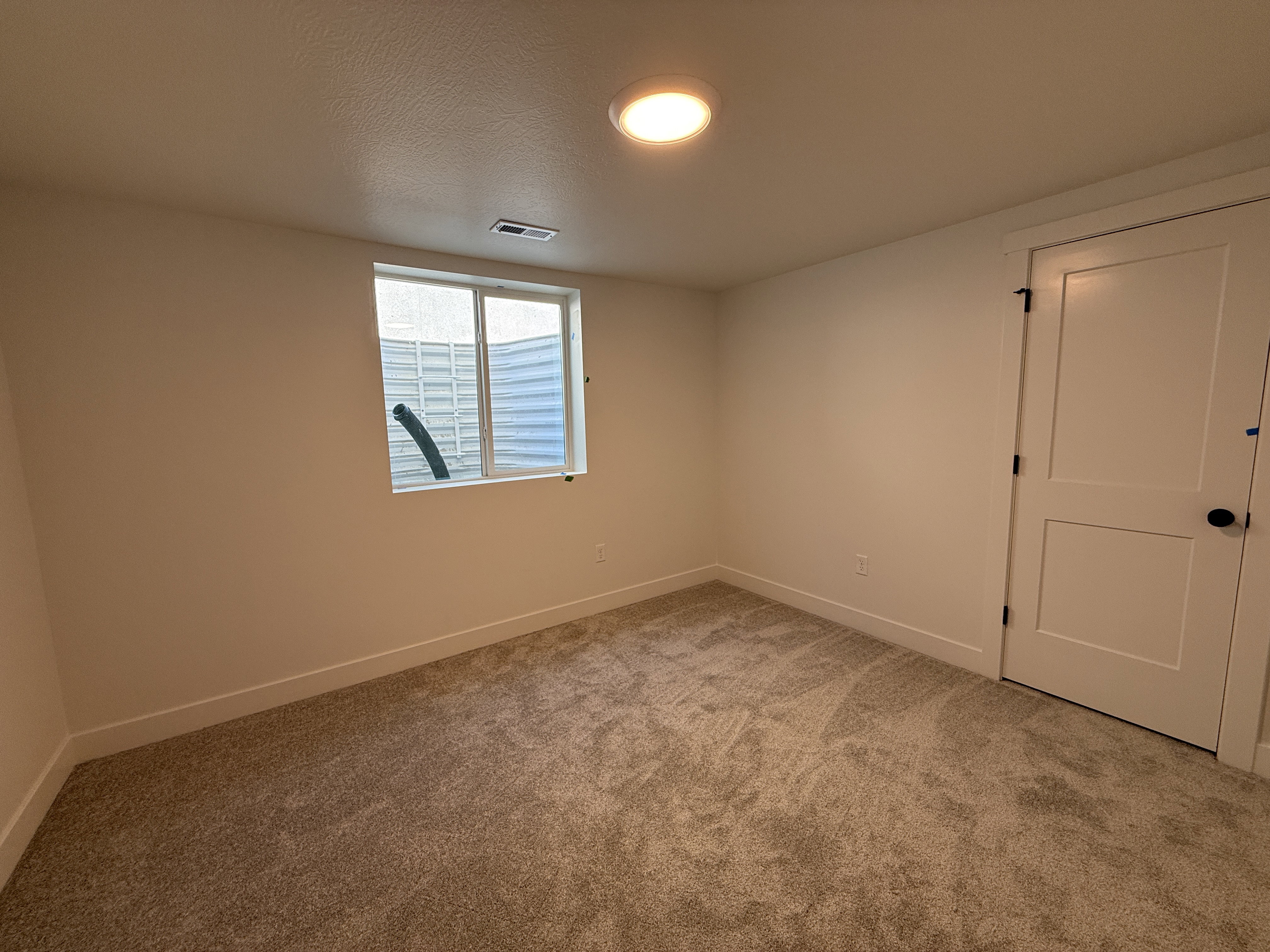 Carpeted room with a recessed window featuring a light well