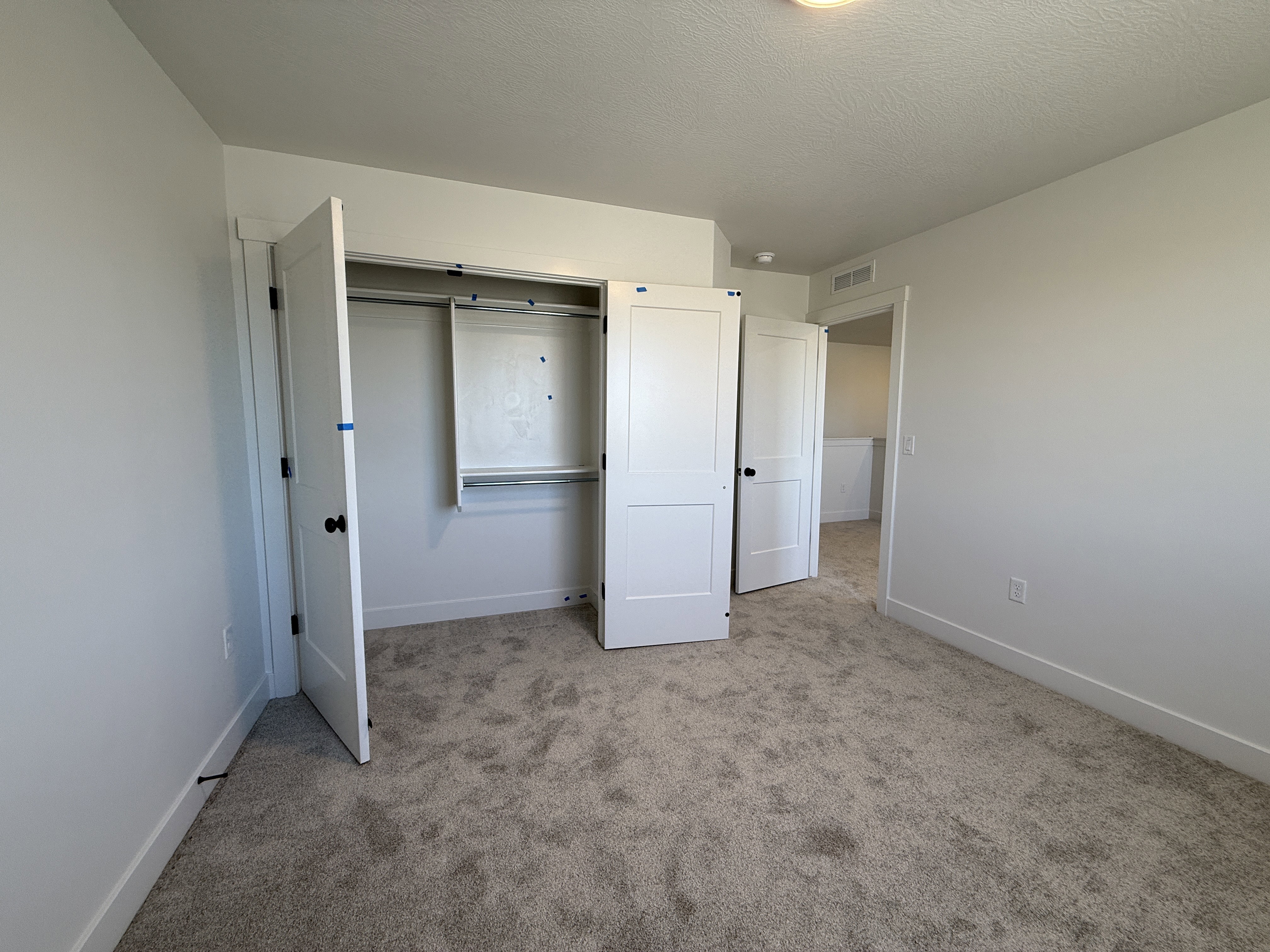 Neutral-toned carpeting extends throughout this interior space, complemented by crisp white walls and white trim