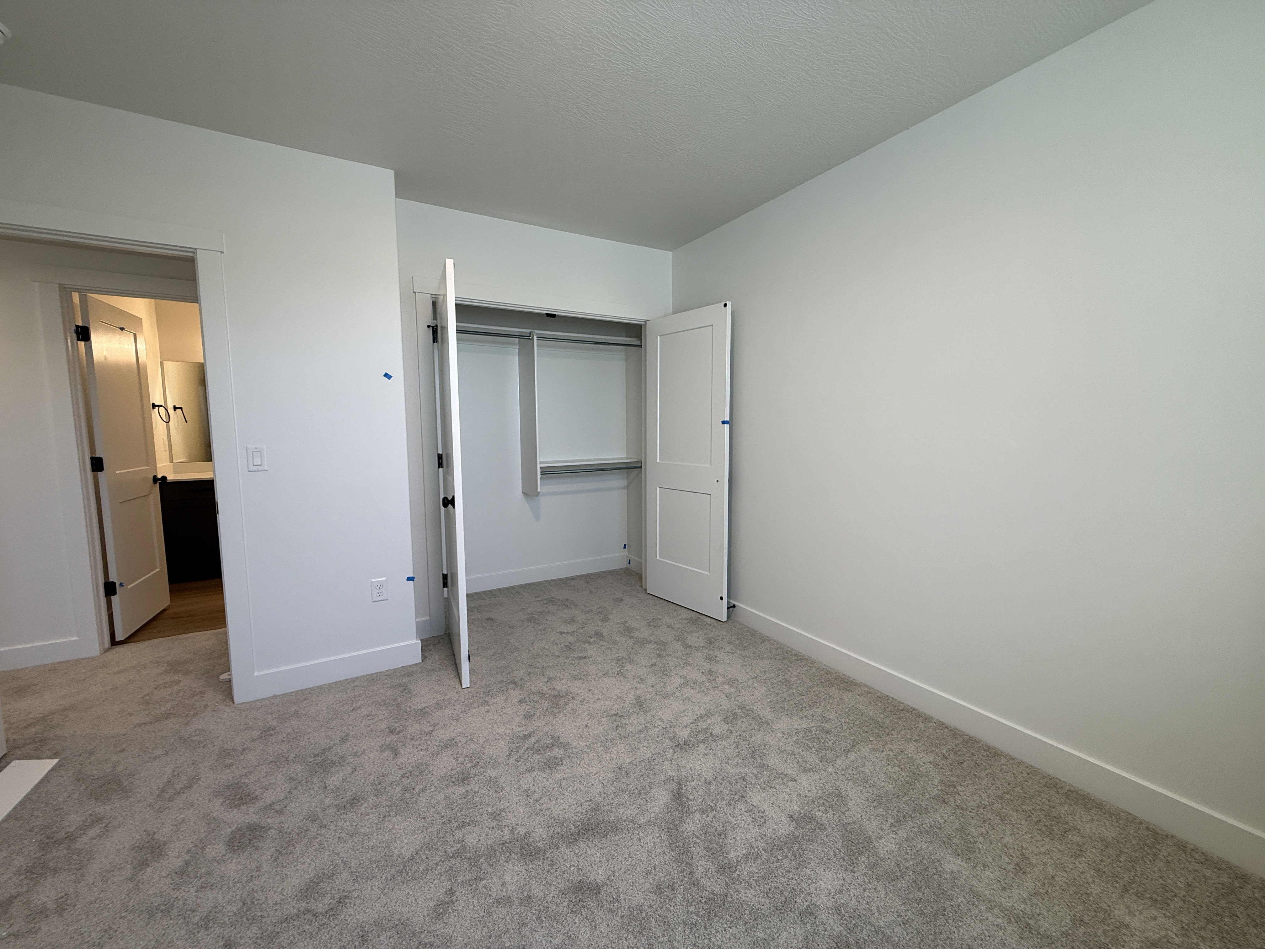 Carpeted room featuring a built-in closet with bi-fold doors and shelving
