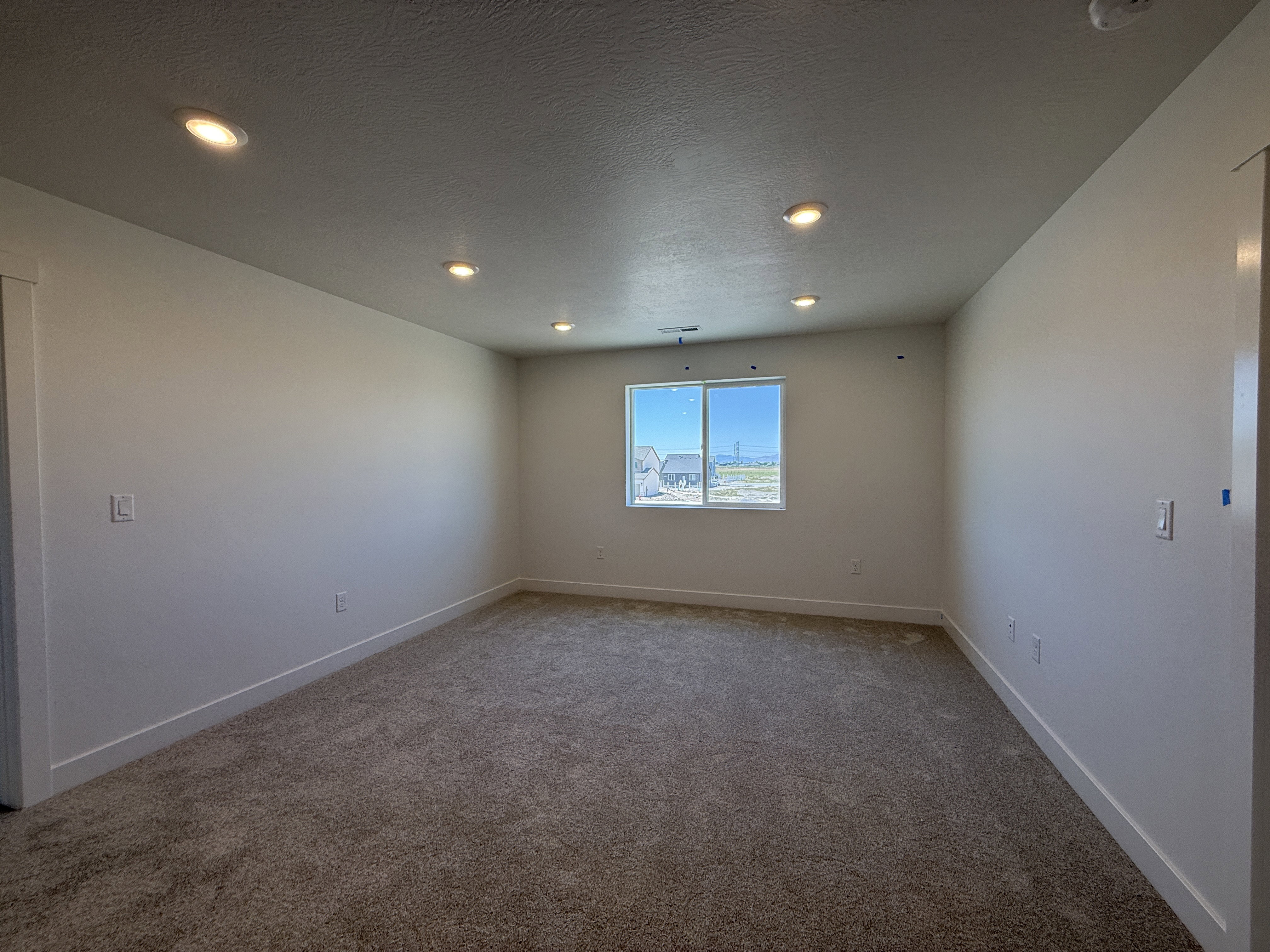 Carpeted room featuring recessed lighting, a single window, and white baseboards