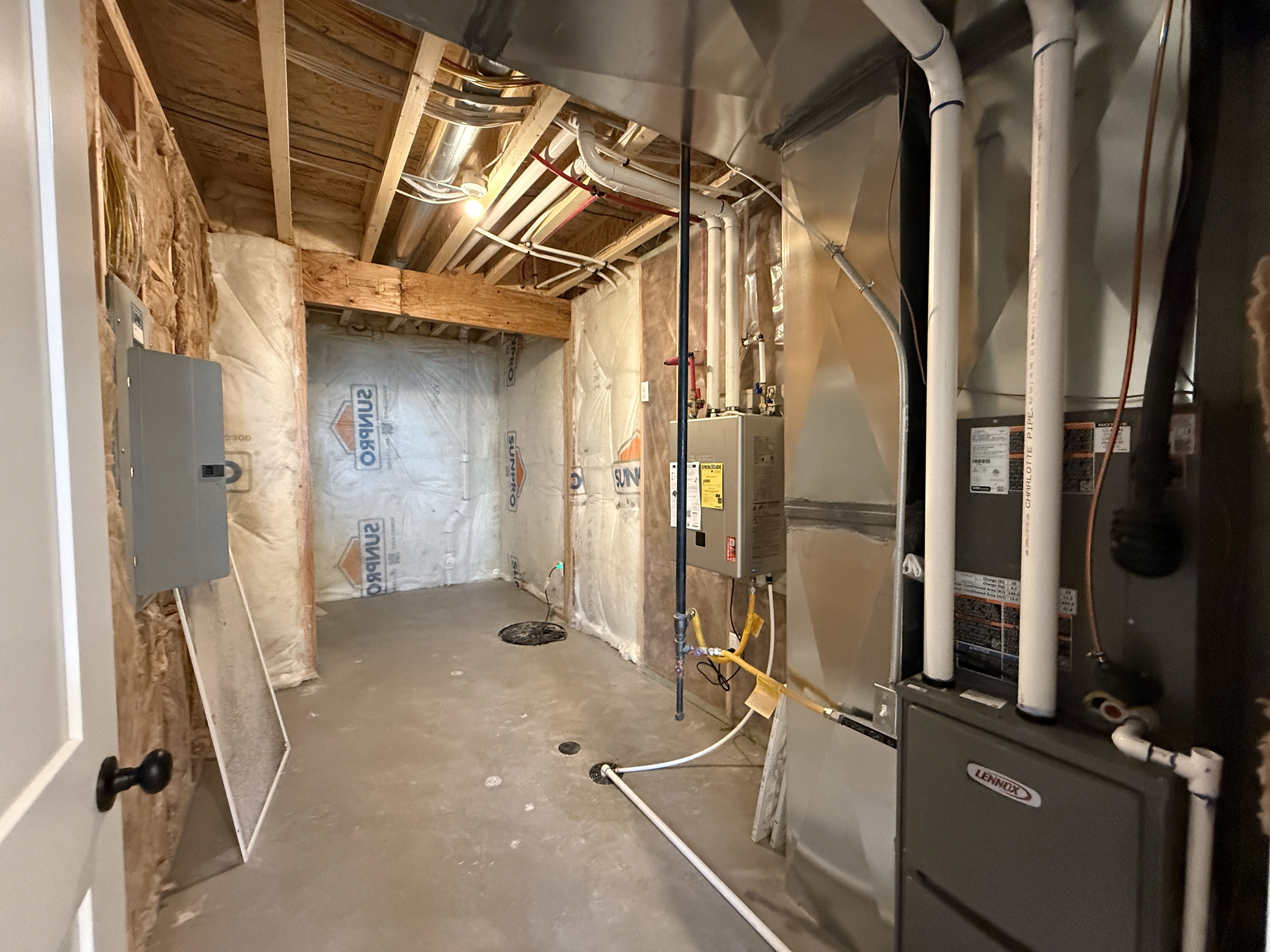 Unfinished basement area featuring exposed wood joists and a concrete floor