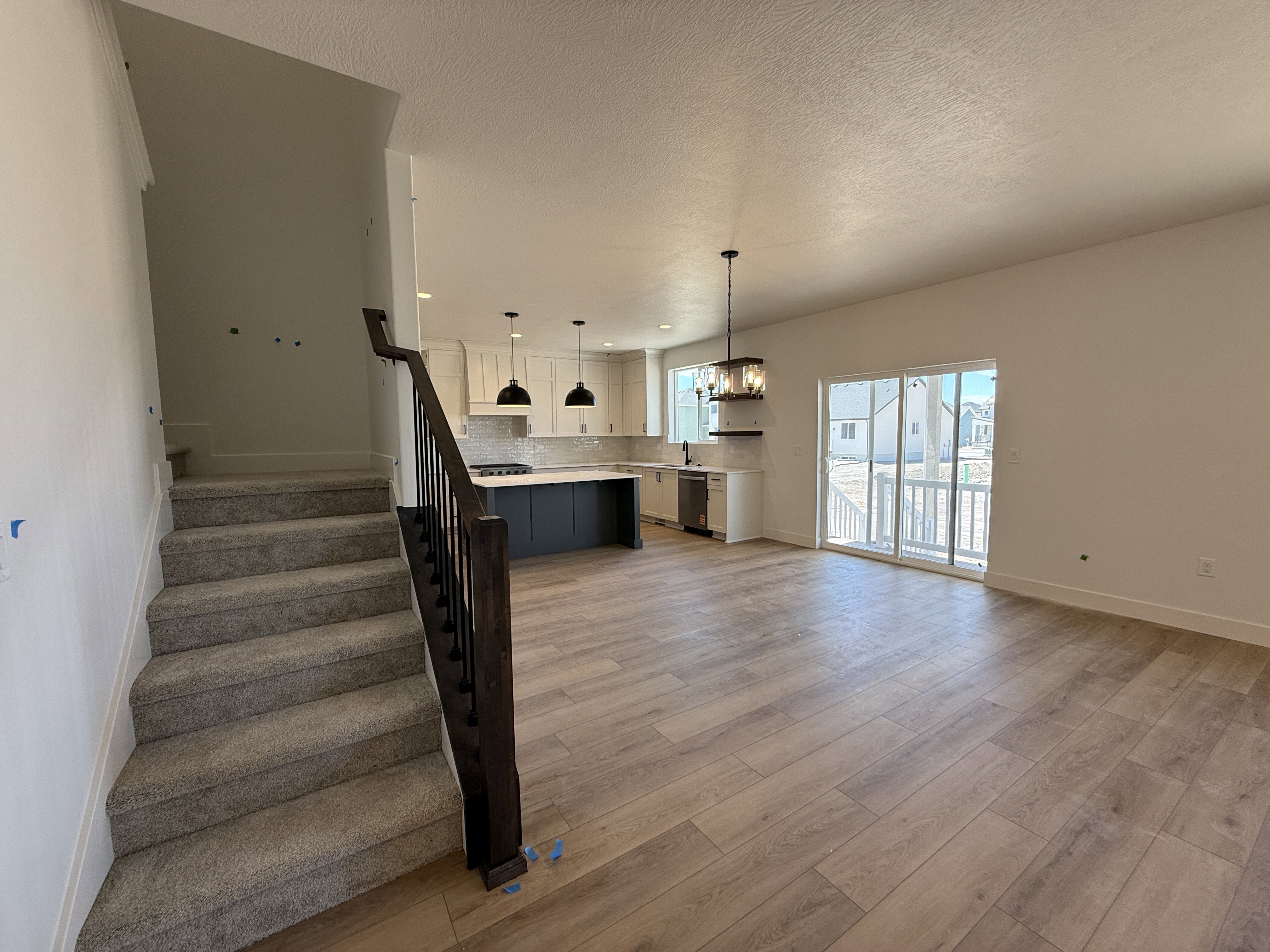 Open-concept living space featuring wood-finish flooring and a contemporary kitchen