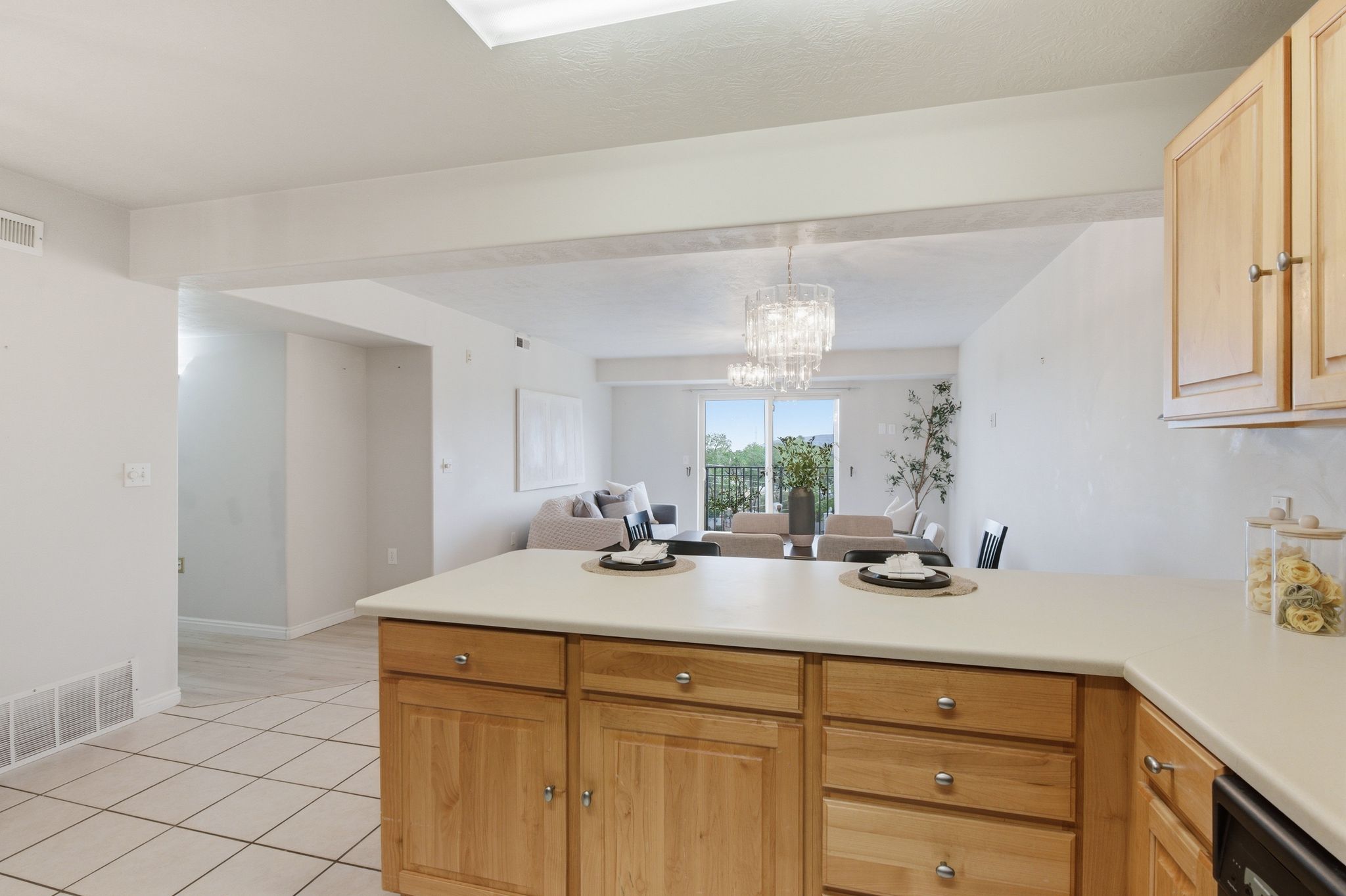 Kitchen island with solid surface countertop and light wood cabinetry