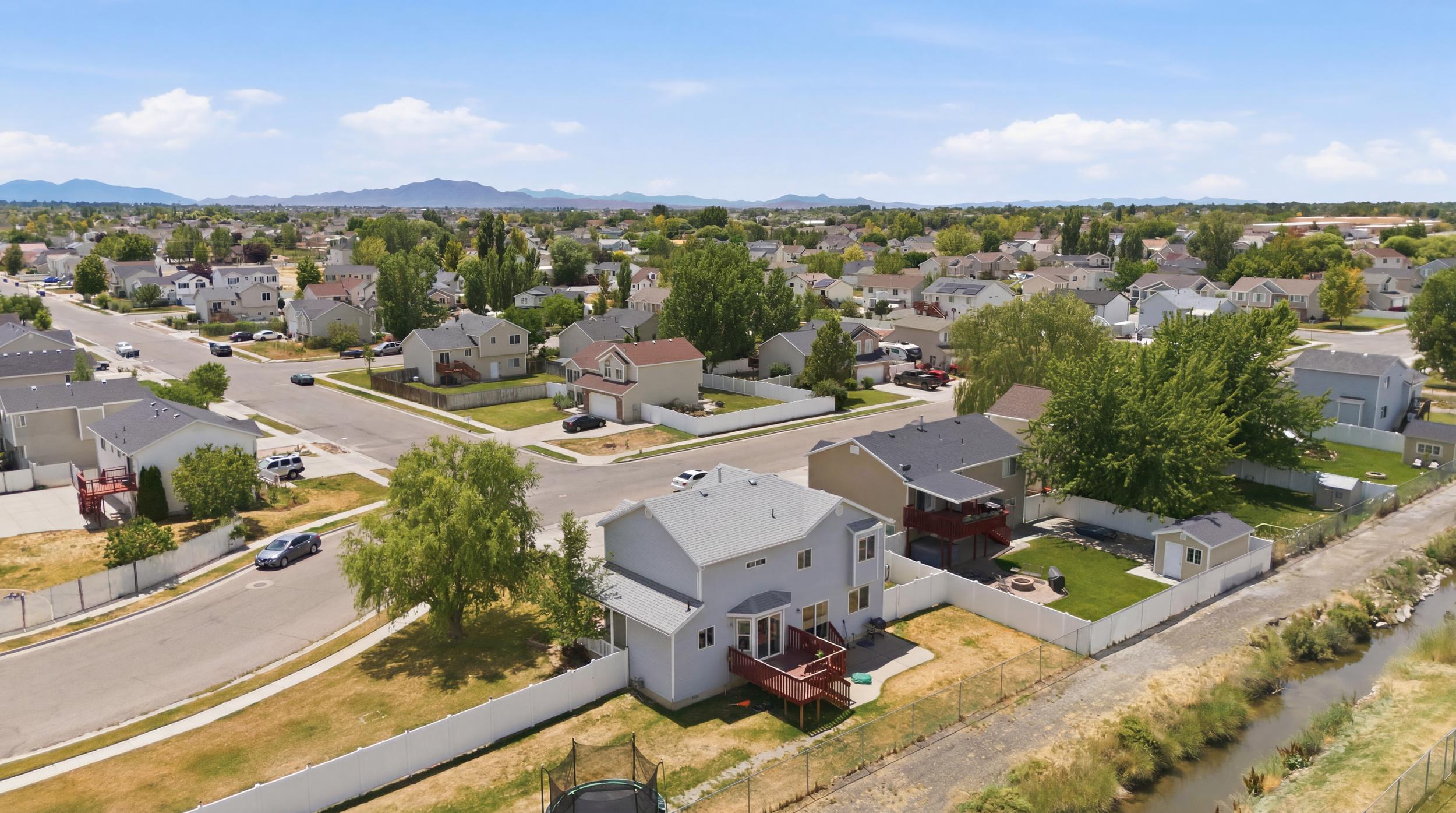 Suburban setting featuring multiple residential properties with pitched roofs and various exterior finishes