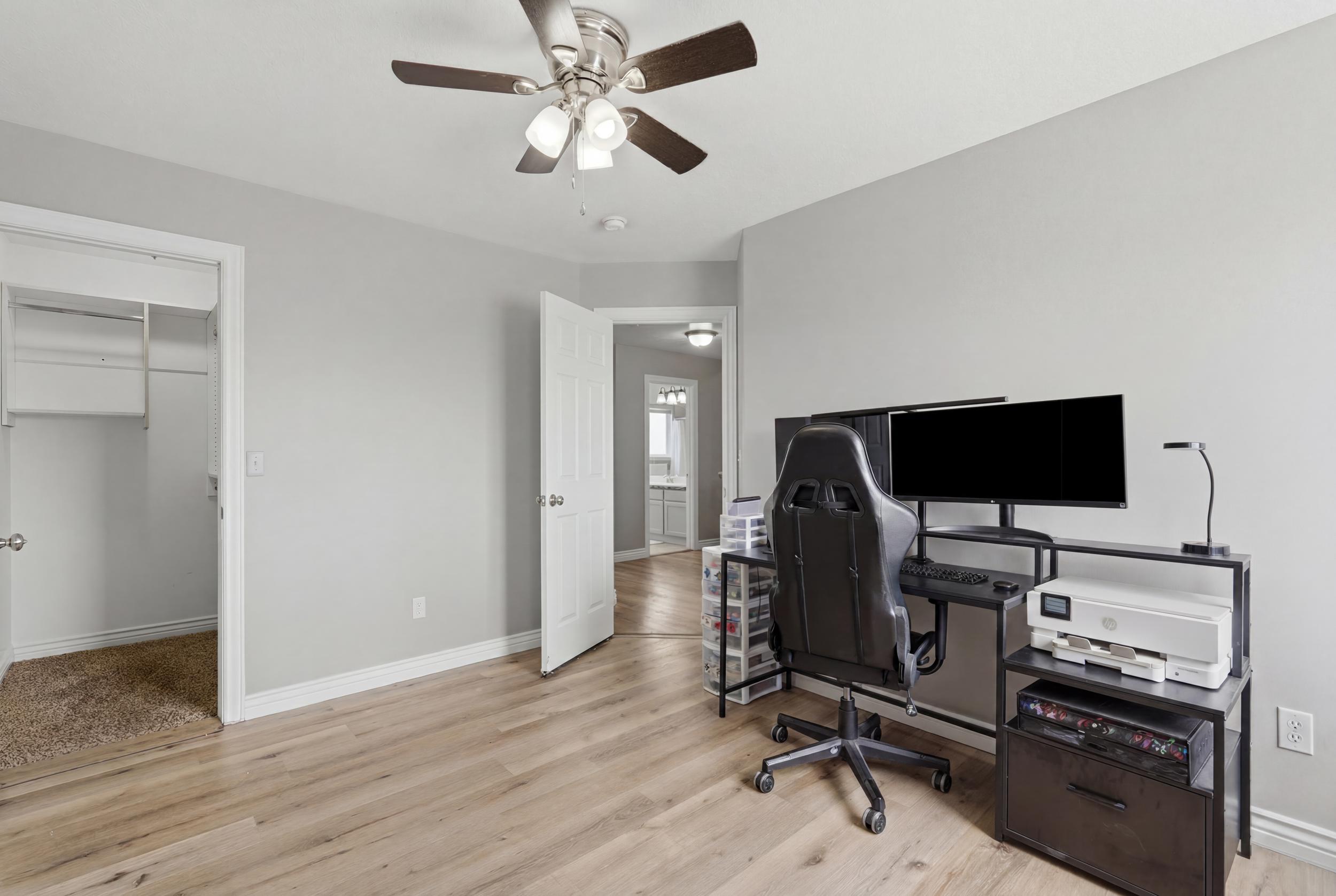 Room featuring wood-finish flooring, light gray wall paint, and white baseboards