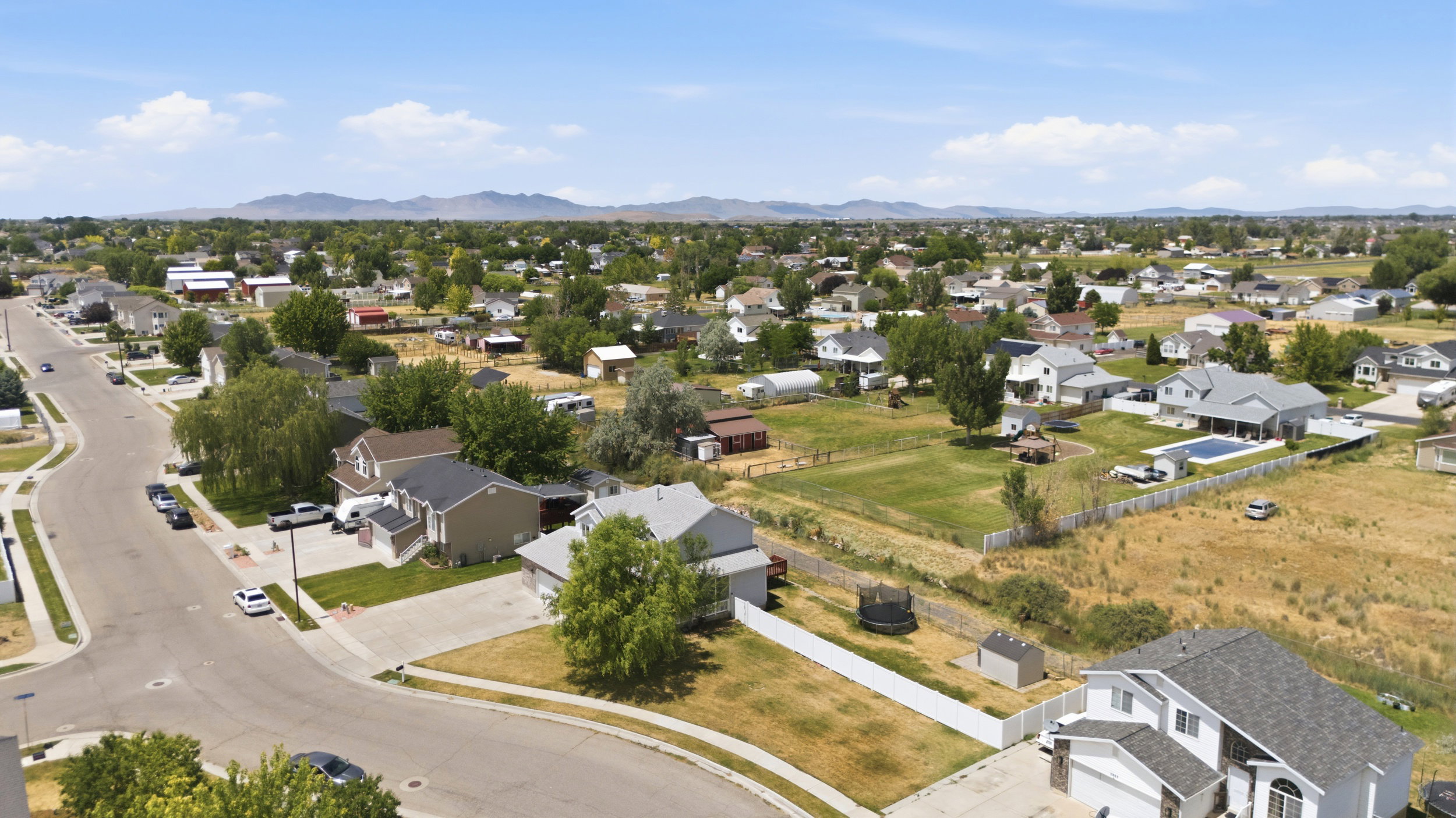 Expansive aerial depiction of a residential area with a mountain backdrop