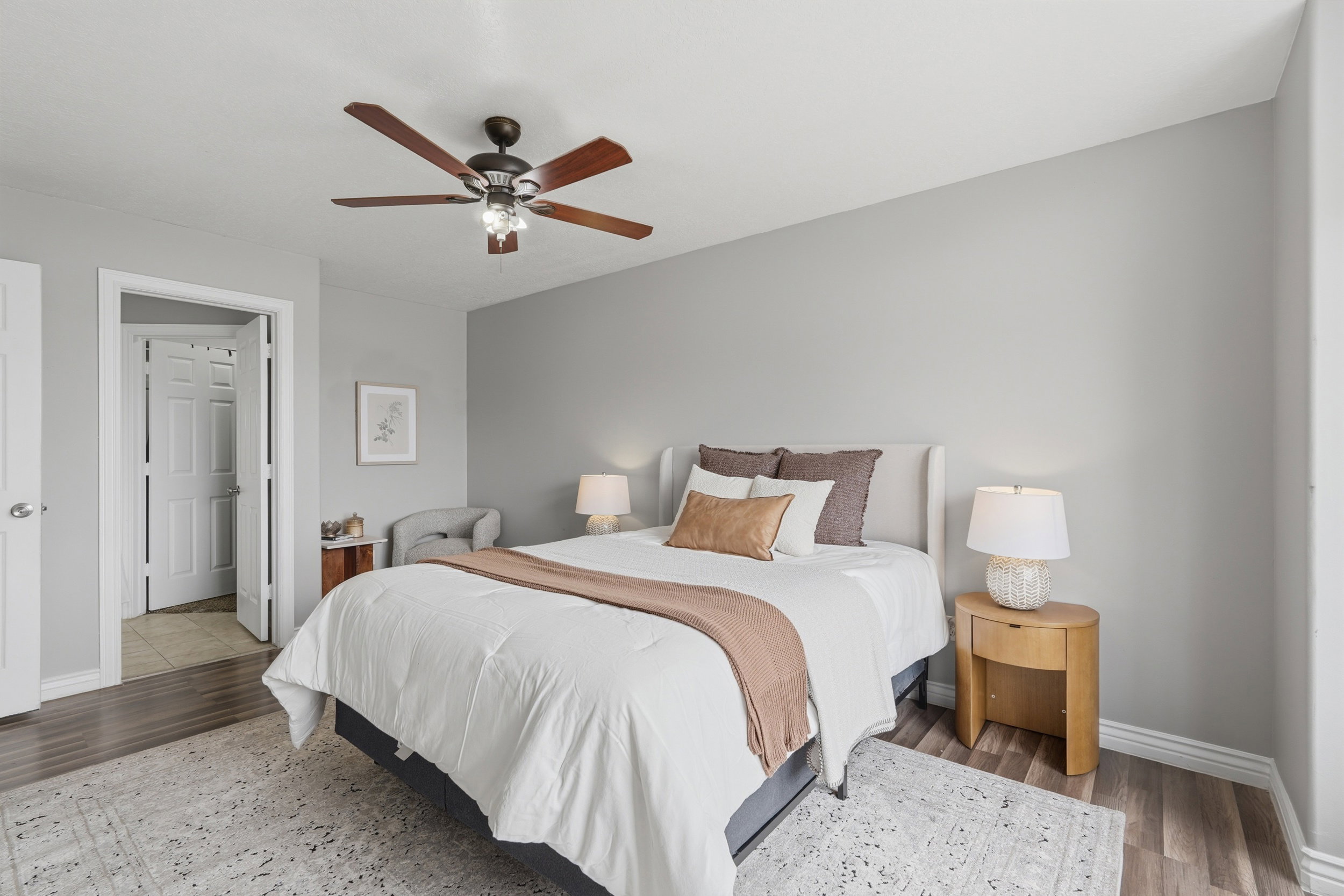 Bedroom featuring wood-finish flooring, a ceiling fan with integrated lighting, and light gray wall paint