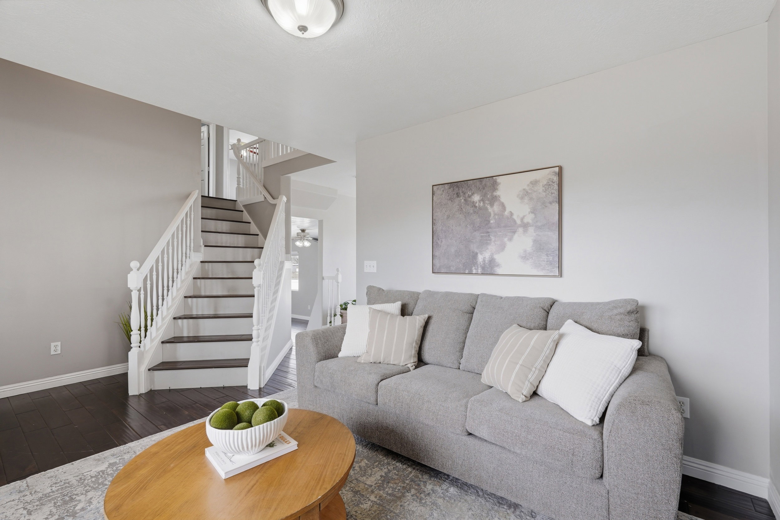 Two-story staircase with dark treads and white risers, featuring white balusters and handrails
