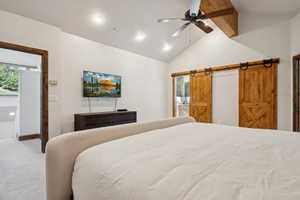 Vaulted ceiling with exposed wood beam and ceiling fan, recessed lighting, and barn doors with dark hardware