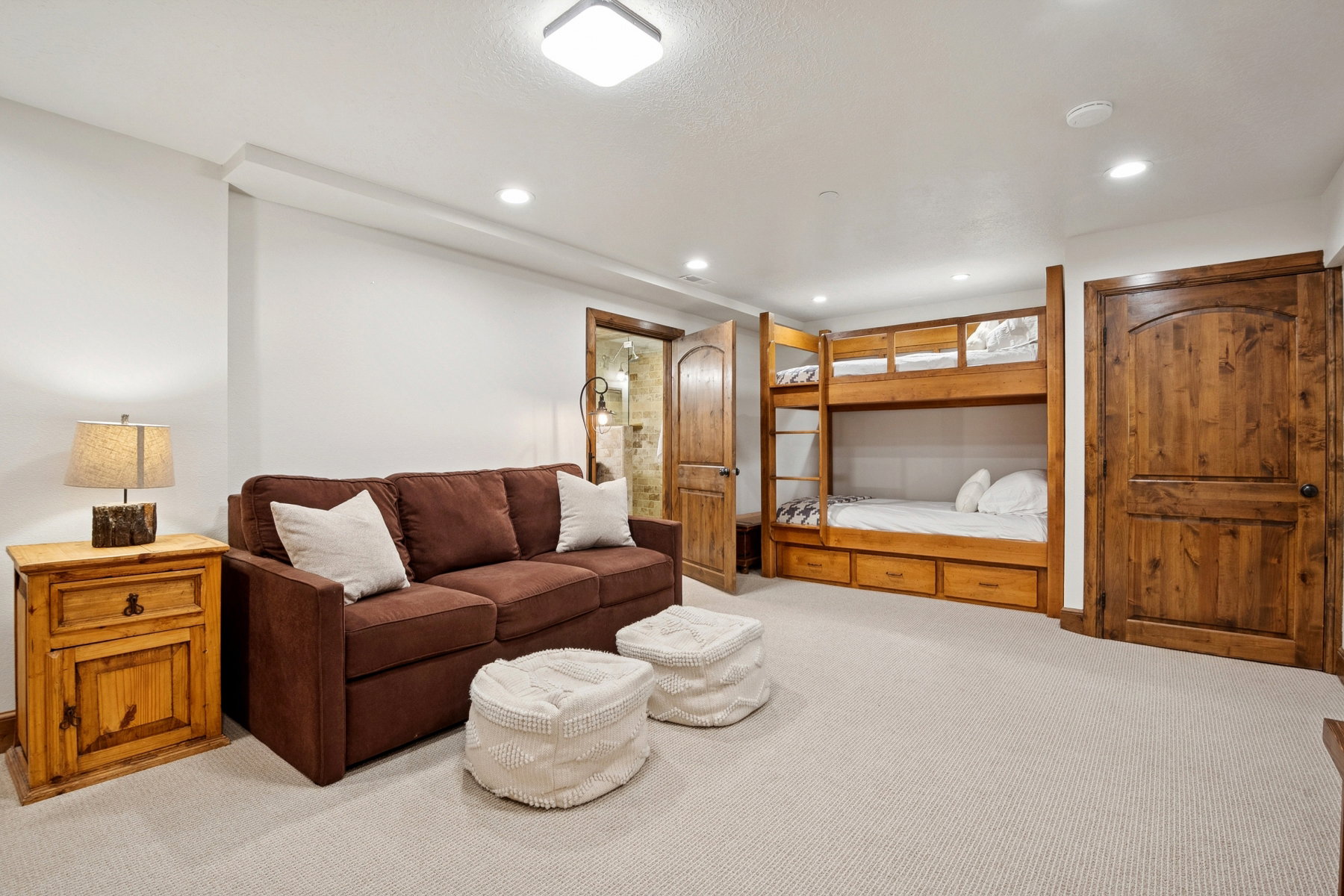 Spacious room featuring light-toned carpeting, recessed lighting, and a built-in wooden bunk bed with storage drawers