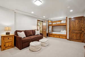 Spacious room featuring light-toned carpeting, recessed lighting, and a built-in wooden bunk bed with storage drawers