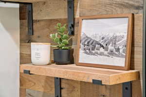 Reclaimed wood accent wall featuring a floating wooden shelf with robust black metal brackets