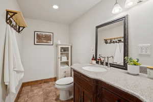 Bathroom featuring a dark wood vanity with a light speckled countertop, undermount sink, and polished chrome faucet