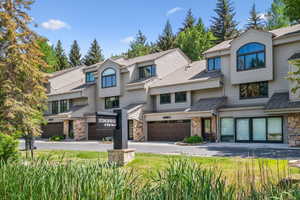 Multi-level townhome exterior featuring natural stone accents and horizontal siding
